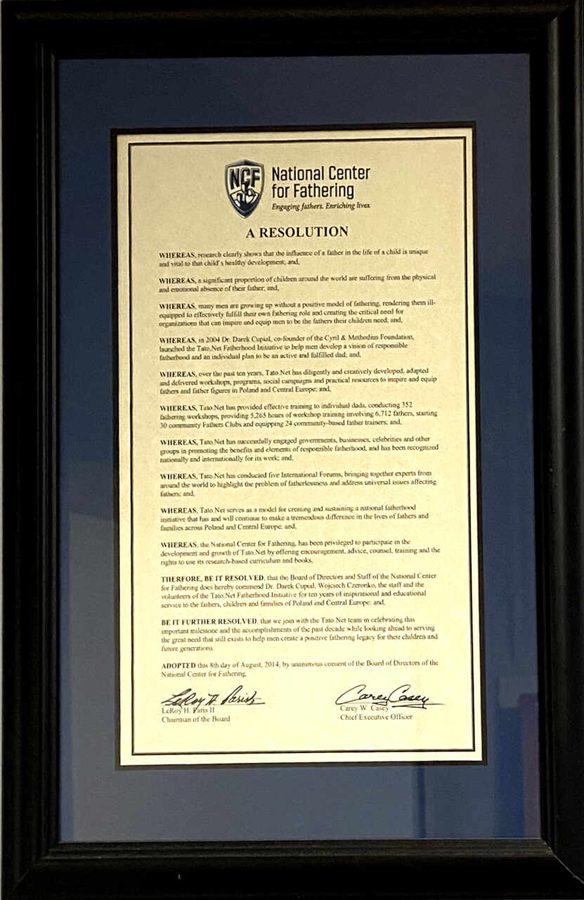 Oficjalna Uchwała Zarządu National Center for Fathering (USA, 2014 r.) z okazji 10-lecia Tato.Net. Wyjątkowy dokument wydany przez amerykańską radę dyrektorów, uznający Tato.Net za modelową inicjatywę ojcowską w Europie Środkowej. Uchwała wyróżnia dr. Dariusza Cupiała oraz Wojciecha Czeronko, podsumowując dekadę sukcesów: 352 warsztaty, powołanie 30 Klubów Ojca i przeszkolenie ponad 6,7 tys. mężczyzn.