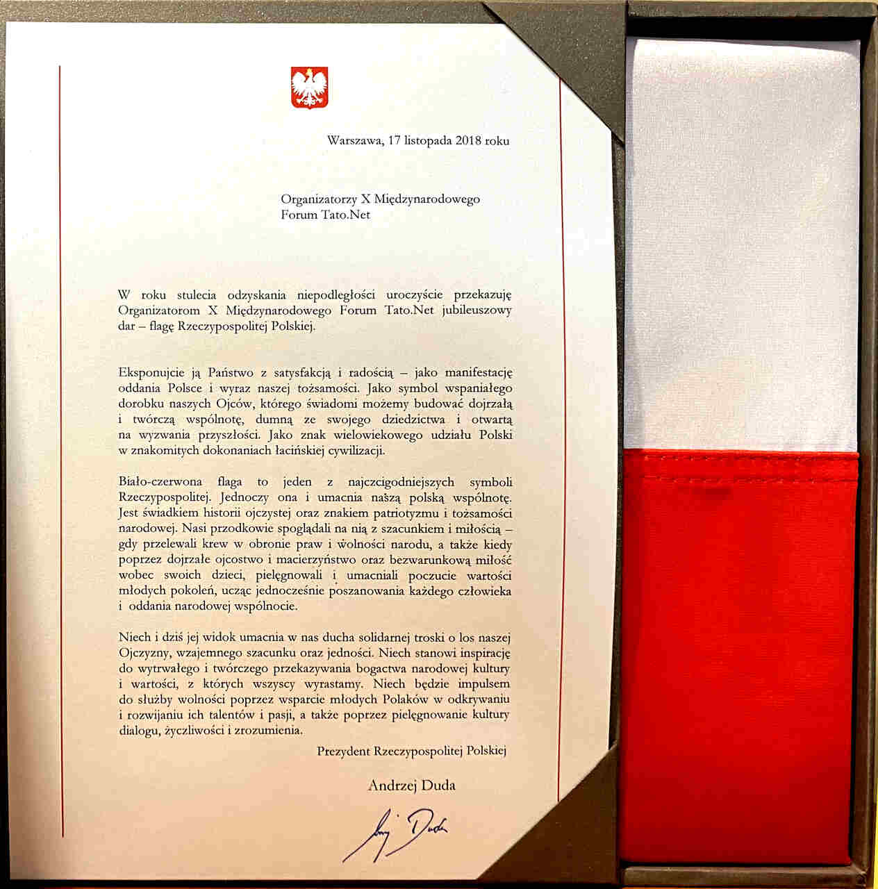 List Prezydenta RP Andrzeja Dudy przekazujący flagę Rzeczypospolitej Polskiej jako jubileuszowy dar dla Organizatorów X Międzynarodowego Forum Tato.Net (2018 r.). Osobiste przesłanie Głowy Państwa w stulecie odzyskania niepodległości, podkreślające rolę dojrzałego ojcostwa w pielęgnowaniu patriotyzmu, tożsamości narodowej oraz wartości młodego pokolenia.